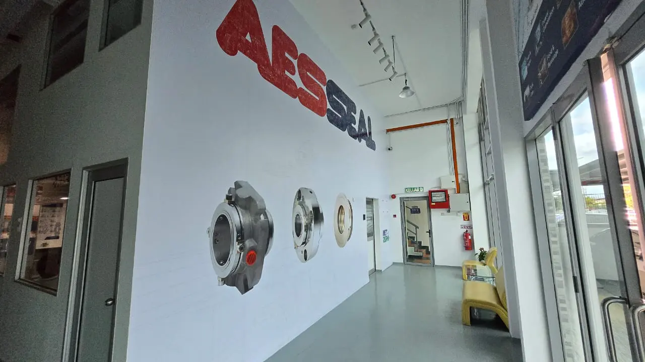 Large AESSEAL branding on a white wall with three seal images beneath. 