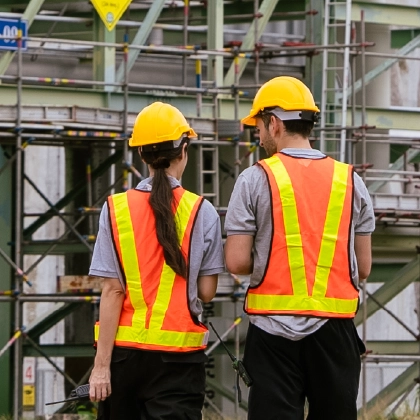 Two engineers stand in front of a chemical plant