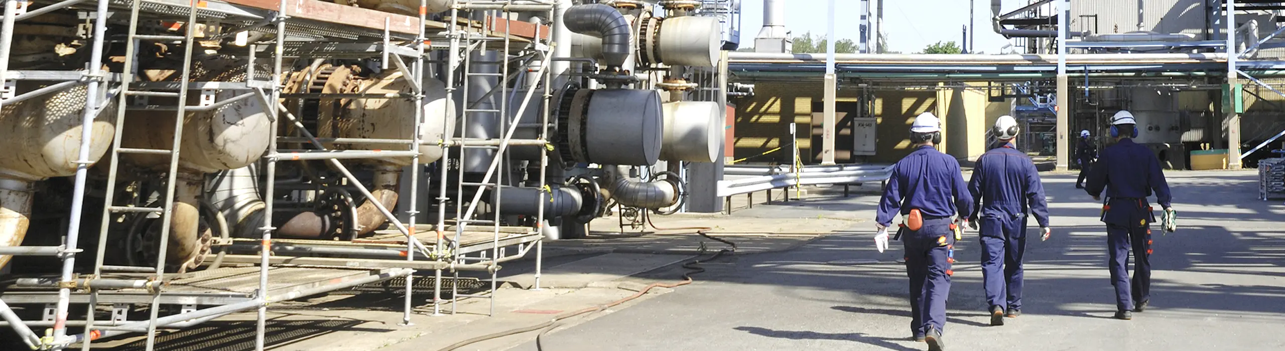Men walking past heavy machinery